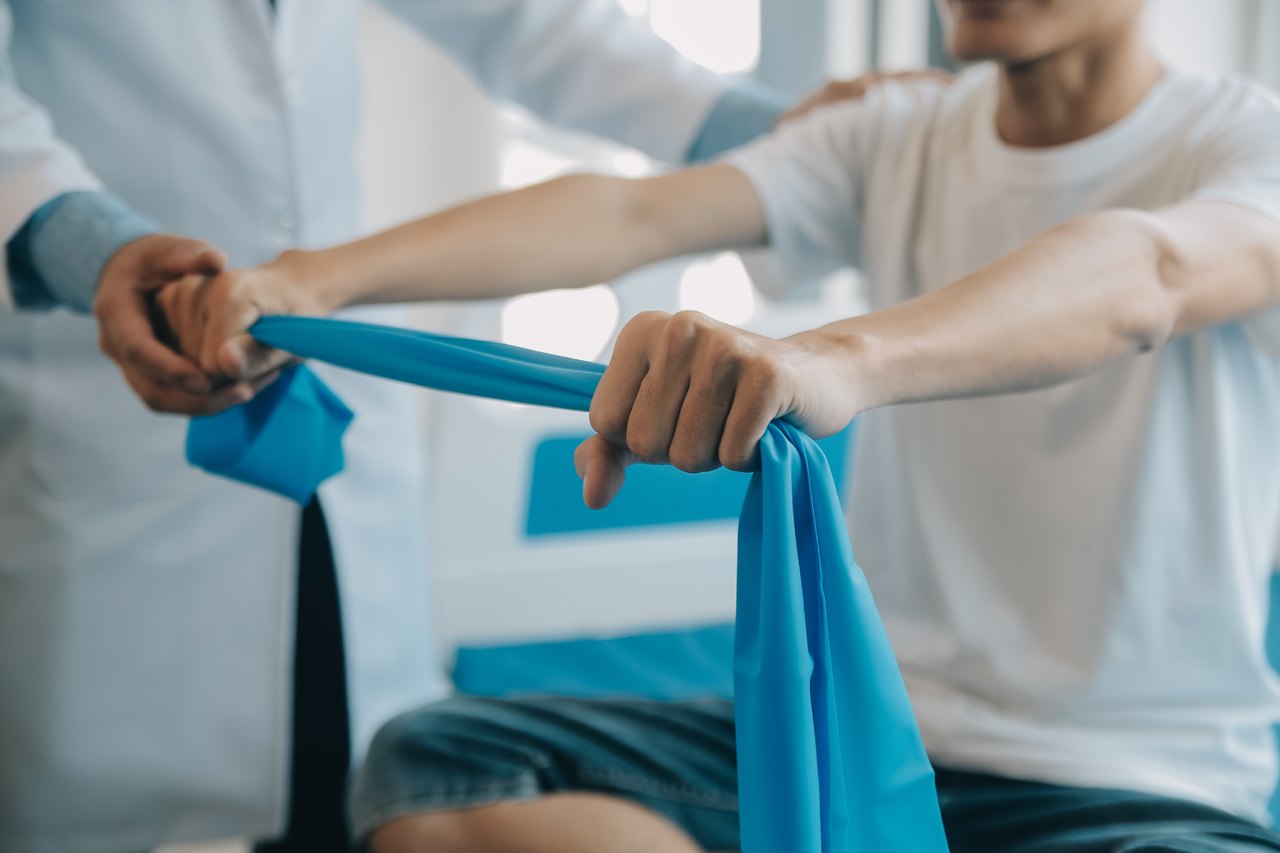 Therapist guiding athlete through resistance band rehab exercises