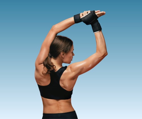 Woman with back pain with hands on hips, and lower back highlighted in red.